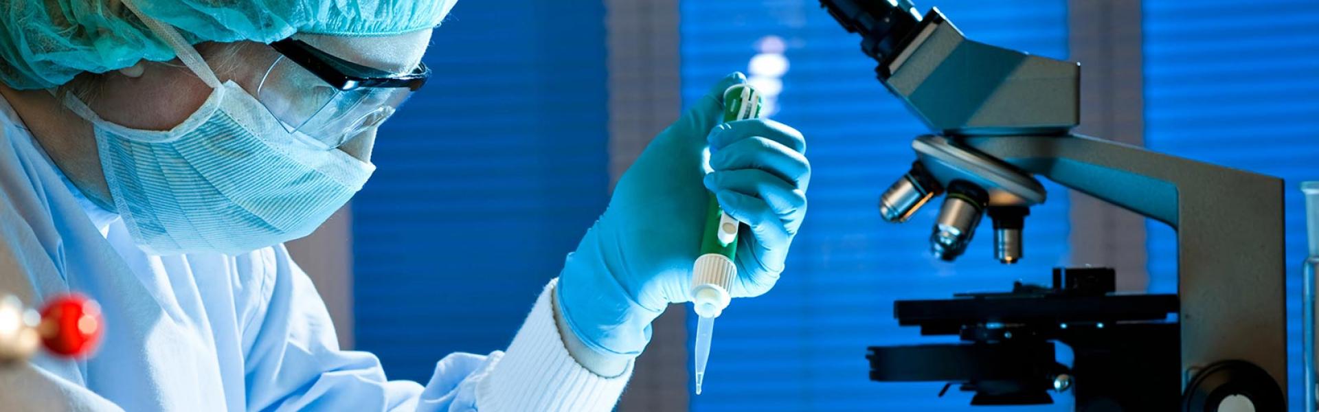 Scienziato con contagocce e microscopio